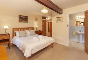 a bedroom with a bed with two towels on it at Mill Cottage in Luxborough