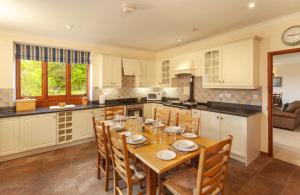 a kitchen with a table and chairs in a kitchen at Mill Cottage in Luxborough