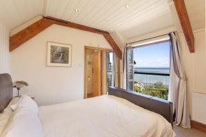 a bedroom with a bed and a large window at The Stable Block, Porlock Weir in Porlock