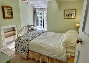 Schlafzimmer mit einem Bett und einem Fenster in der Unterkunft Orchard Cottage in Charles
