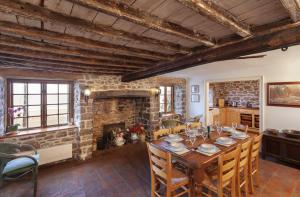 a dining room with a table and a fireplace at The Crows Nest in Porlock