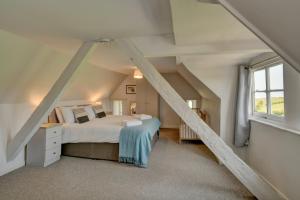 a attic bedroom with a bed and a window at Yenworthy Cottage in Culbone