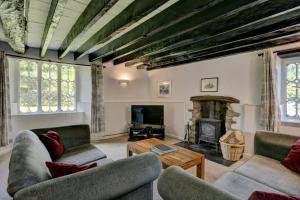 a living room with two couches and a fireplace at Yenworthy Cottage in Culbone