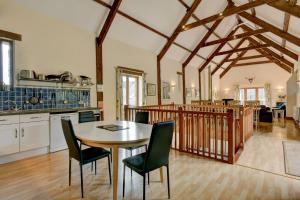 a kitchen and dining room with a table and chairs at Yenworthy Barn in Culbone