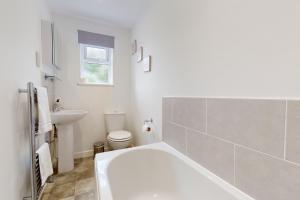 a white bathroom with a tub and a sink at Plum Tree Cottage, Porlock in Porlock +24 photos