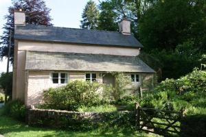 una vieja casa de piedra con una puerta delante de ella en Ball Cottage en Winsford