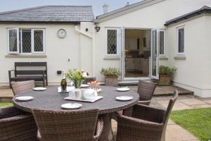 a table and chairs in the backyard of a house at Plum Tree Cottage, Porlock in Porlock
