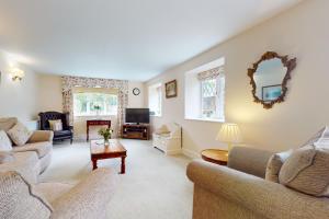 a living room with two couches and a tv at Plum Tree Cottage, Porlock in Porlock