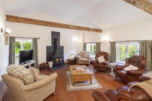 a living room with leather furniture and a fireplace at The Mill House in Bampton