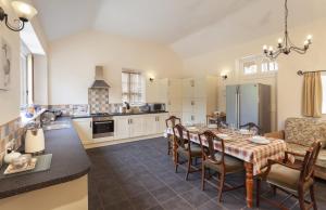 cocina y comedor con mesa y sillas en The Mill House en Bampton