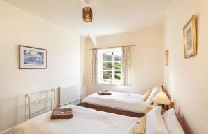 una camera con due letti e una finestra di Farm Cottage, West Luccombe a Porlock