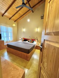 - une chambre avec un lit et un ventilateur de plafond dans l'établissement Art Yala, à Tissamaharama