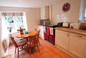 a kitchen with a table and a table and chairs at Magnolia Cottage in Porlock