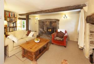 a living room with a couch and a fireplace at Old Church House, Brayford in Highbray