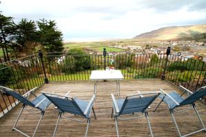 einen Tisch und Stühle auf einer Terrasse mit Aussicht in der Unterkunft Redway Lodge in Porlock