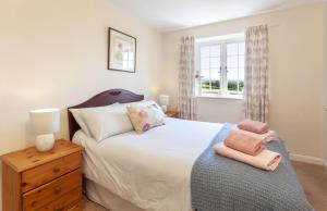 um quarto com uma cama grande e uma janela em Jacobs Pond, Near Monksilver em Stogumber