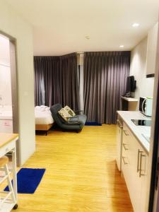 a small room with a bed and a kitchen and a room at Grand Blue Condominium by Mary in Mae Pim