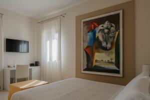 1 dormitorio con 1 cama y una pintura en la pared en Villa Patrizia Salento Art & Room, en Porto Cesareo