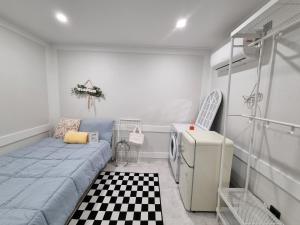 um pequeno quarto com uma cama e um frigorífico em Urban Stay Anyang em Anyang