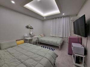 a bedroom with a bed and a desk and a tv at Urban Stay Anyang in Anyang