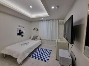 Urban Stay Anyang في Anyang: غرفة نوم بسرير وتلفزيون بشاشة مسطحة