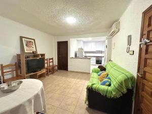 ein Wohnzimmer mit einem Sofa und einer Küche in der Unterkunft 2 dormitorios 95 m de la playa in Los Alcázares