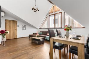 un soggiorno con un tavolo e un divano di ARI Central Grand SkyView - Family Apartment a Arad