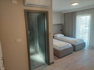 a bedroom with two beds and a sliding glass door at Pensiunea Normandia in Timişoara