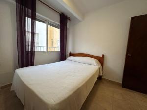 ein Schlafzimmer mit einem weißen Bett und einem Fenster in der Unterkunft 2 dormitorios 95 m de la playa in Los Alcázares