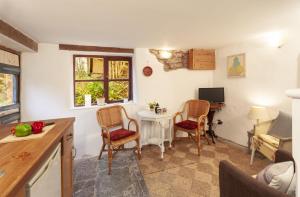 een keuken met een tafel en 2 stoelen en een bureau bij Garden Cottage, Wiveliscombe in Wiveliscombe