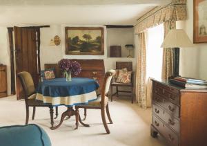 ein Zimmer mit Tisch und Stühlen und einer Kommode in der Unterkunft Bratton Mill Farmhouse in Bratton Fleming