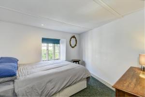 a white bedroom with a bed and a window at Riverside Cottage, Brendon in Countisbury