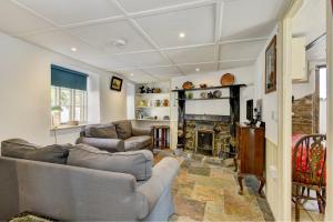 a living room with two couches and a fireplace at Riverside Cottage, Brendon in Countisbury