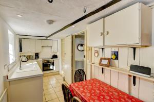 a kitchen with white cabinets and a red table in a room at Riverside Cottage, Brendon in Countisbury