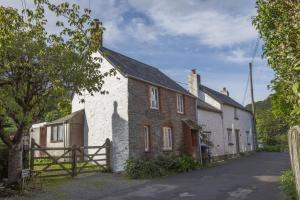 an old house with a fence in front of it at Riverside Cottage, Brendon in Countisbury