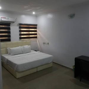 a bedroom with a bed in a white room at Elstine’s in Lagos