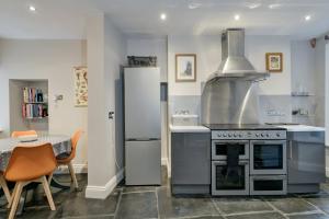 a kitchen with a stove and a dining table at 48 Swain Street, Watchet in Watchet