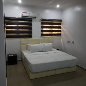 a bedroom with a bed in a room with windows at Elstine’s in Lagos