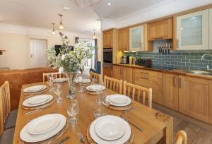 a kitchen with a wooden table with plates on it at The Dog House, Porlock in Porlock