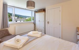 a bedroom with a bed and a large window at The Dog House, Porlock in Porlock