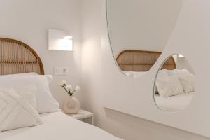 een witte slaapkamer met een spiegel en een bed bij ISG Apartments Cuna 10 in Sevilla +29 foto's