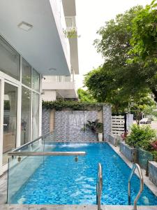 uma piscina com duas cadeiras ao lado de um edifício em Villa Sao Biển SB14 FLC Sầm Sơn em Sam Son