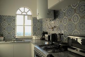 a kitchen with a stove and a window at Bernardita in Ramos Mejía