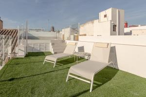 een rij stoelen op het gras op een dak bij ISG Apartments Cuna 10 in Sevilla