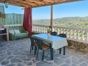un patio con tavolo, sedie e divano di Casa cueva El Balcón del Cortijo a Teror