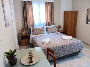 a small bedroom with a bed and a table at DIMITRA STUDIOS in Lefkada Town