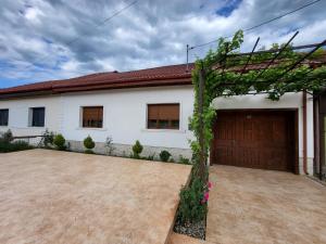 a large white house with a garage at CASA DIN SAT in Eşelniţa