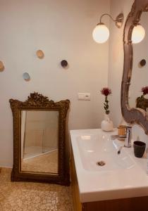 La salle de bains est pourvue d'un miroir et d'un lavabo. dans l'établissement Maison d'Hôtes " L'INSTANT D'AILLEURS", à Albi