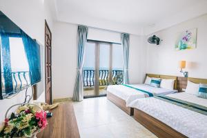 a hotel room with two beds and a balcony at Hương Lý Hotel in Sầm Sơn
