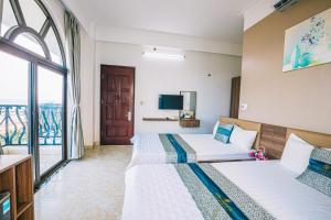 a hotel room with two beds and a window at Hương Lý Hotel in Sầm Sơn